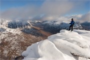 Hill walker on the summit of Tom na Gruagaich (922m) in winter, Beinn Alligin, Torridon, Scotland